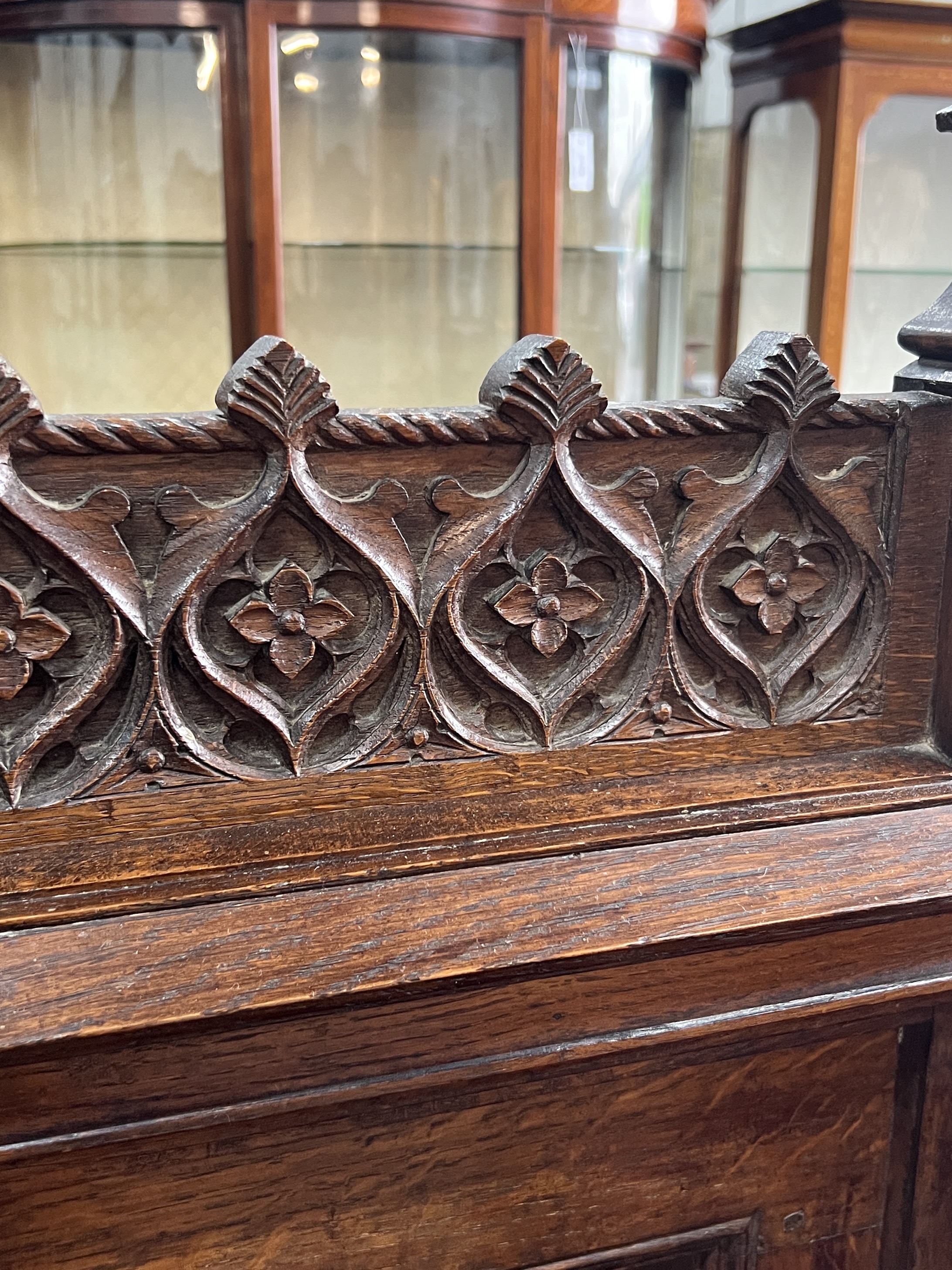 An early 20th century carved oak Gothic Revival settle with hinged box seat, width 137cm, depth 49cm, height 160cm